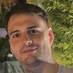 Porträt von Carl-Magnus Bahner, FDP, Oberbürgermeisterkandidat für die Oberbürgermeisterwahl 2026 in Fürstenfeldbruck, Nahaufnahme vor grünem Pflanzenhintergrund.