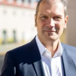 Porträt von Christian Götz, BBV, Oberbürgermeisterkandidat für die Oberbürgermeisterwahl 2026 in Fürstenfeldbruck, im Freien im dunklen Sakko und weißem Hemd.